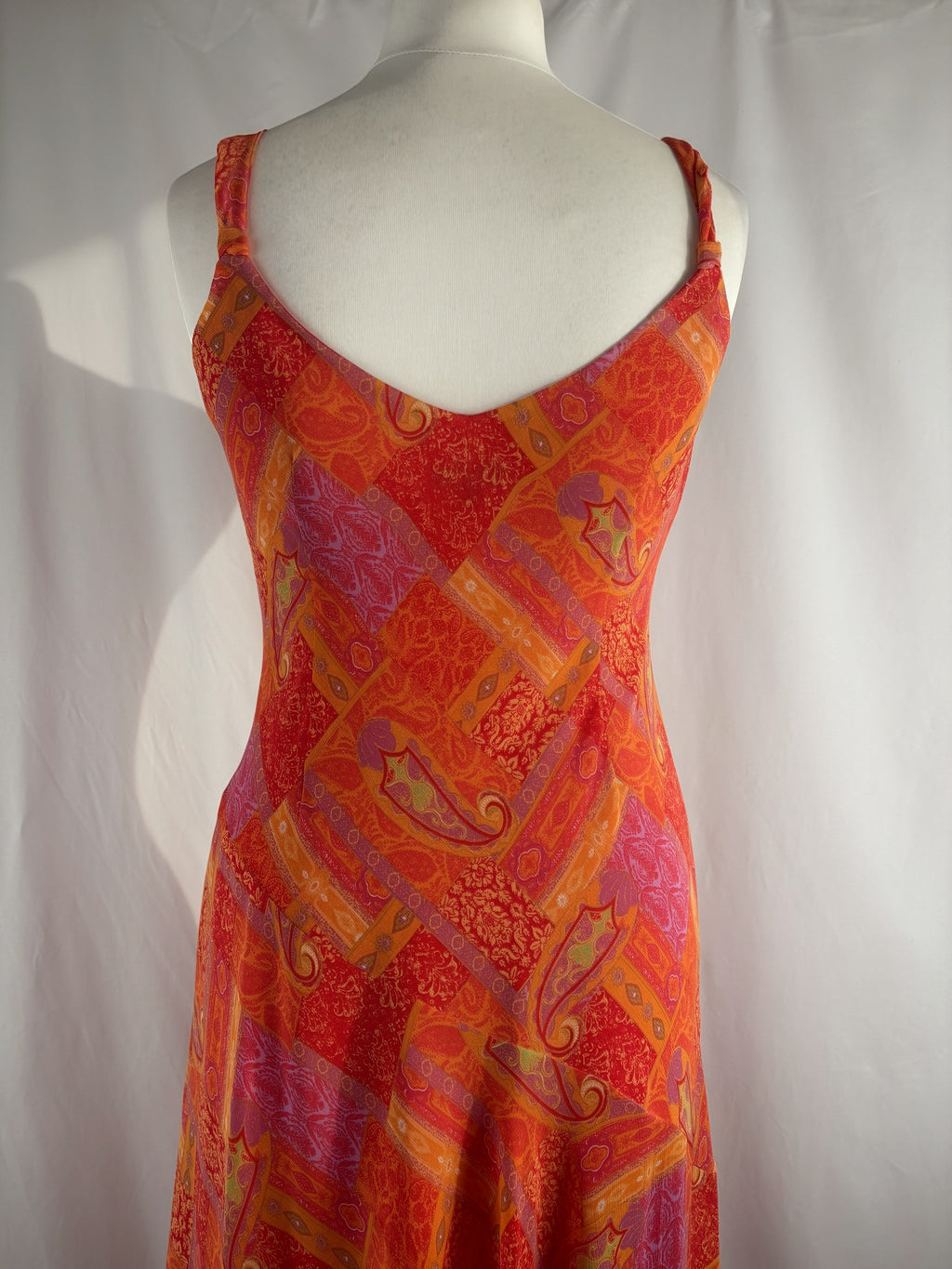 Orange paisley patchwork style midi dress with asymmetric hem