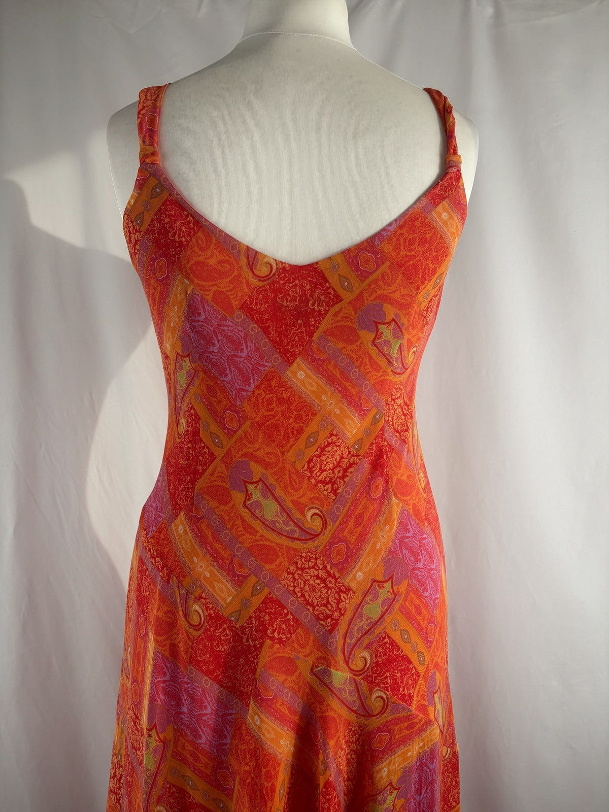 Orange paisley patchwork style midi dress with asymmetric hem