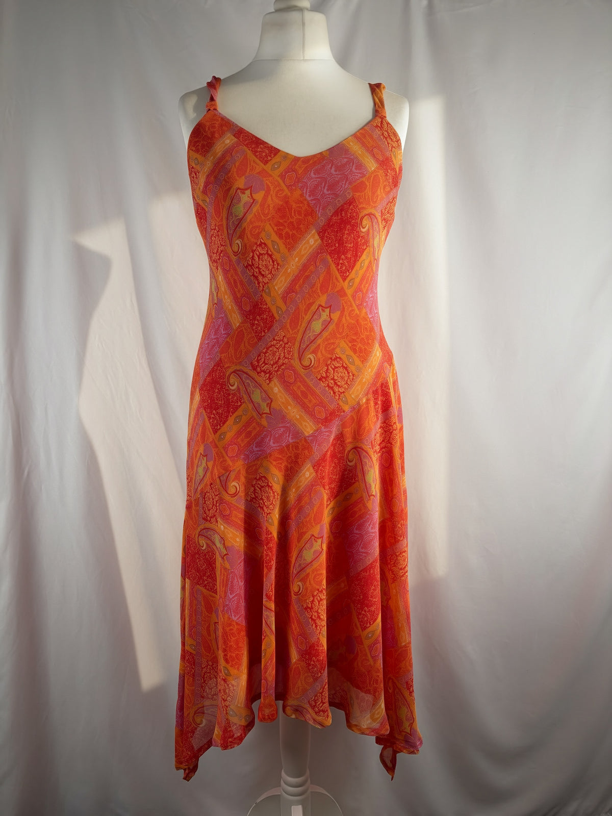 Orange paisley patchwork style midi dress with asymmetric hem