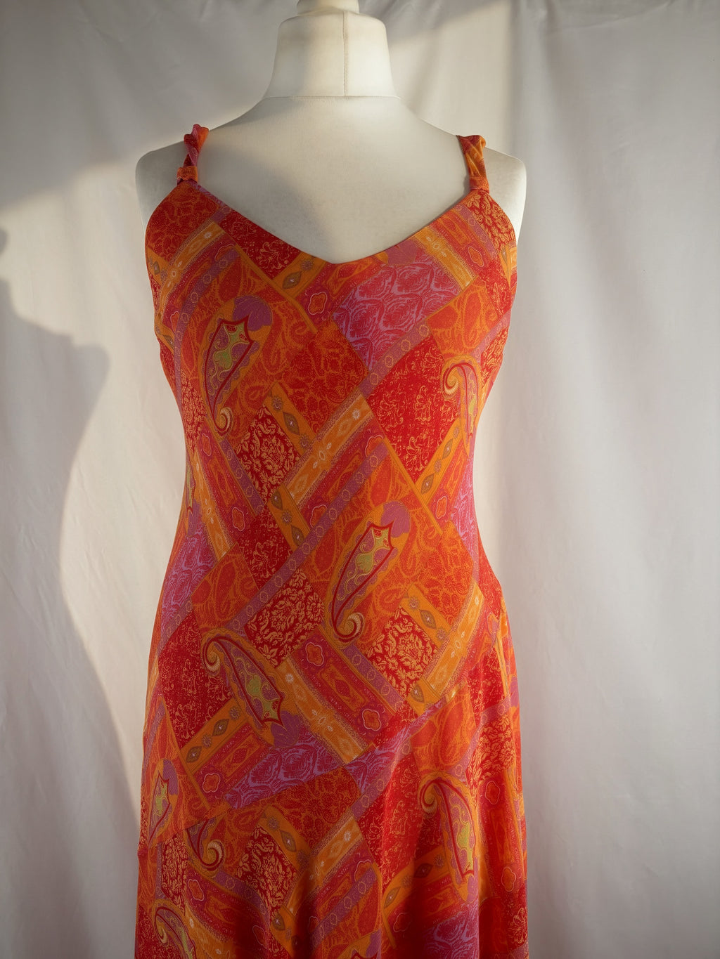 Orange paisley patchwork style midi dress with asymmetric hem